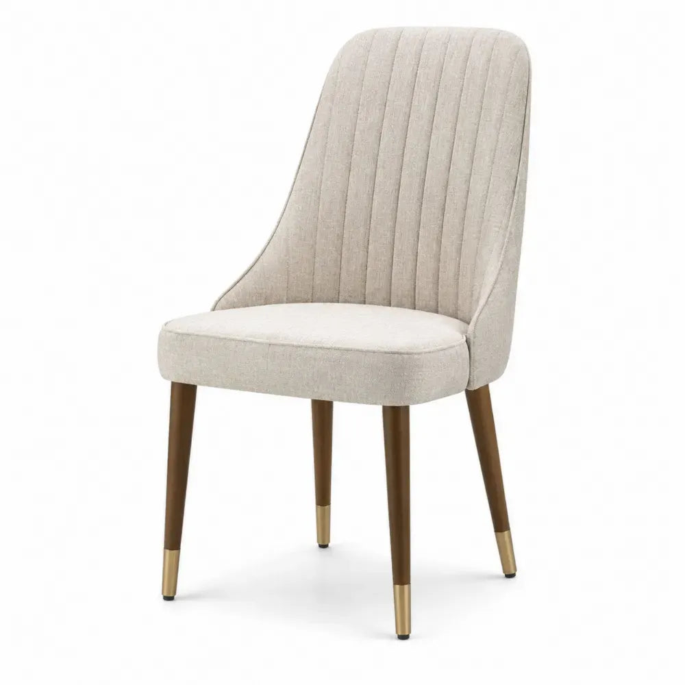 Silla de comedor tapizada en tejido beige con respaldo alto acanalado patas de madera marrón y remates dorados 55 x 55 x 85 cm